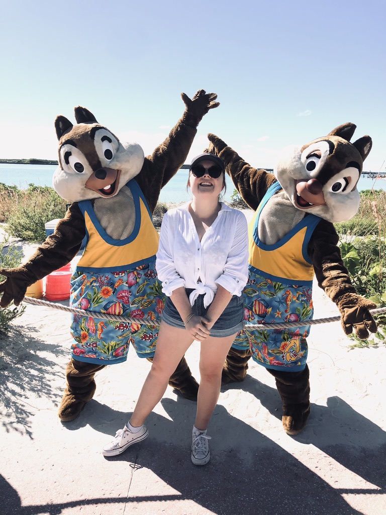 Girl smiling with Chip and Dale disney characters at castaway cay.