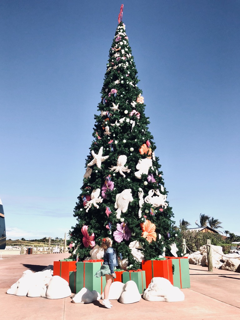 Girl twirling in front of Christmas tree on Castaway Cay