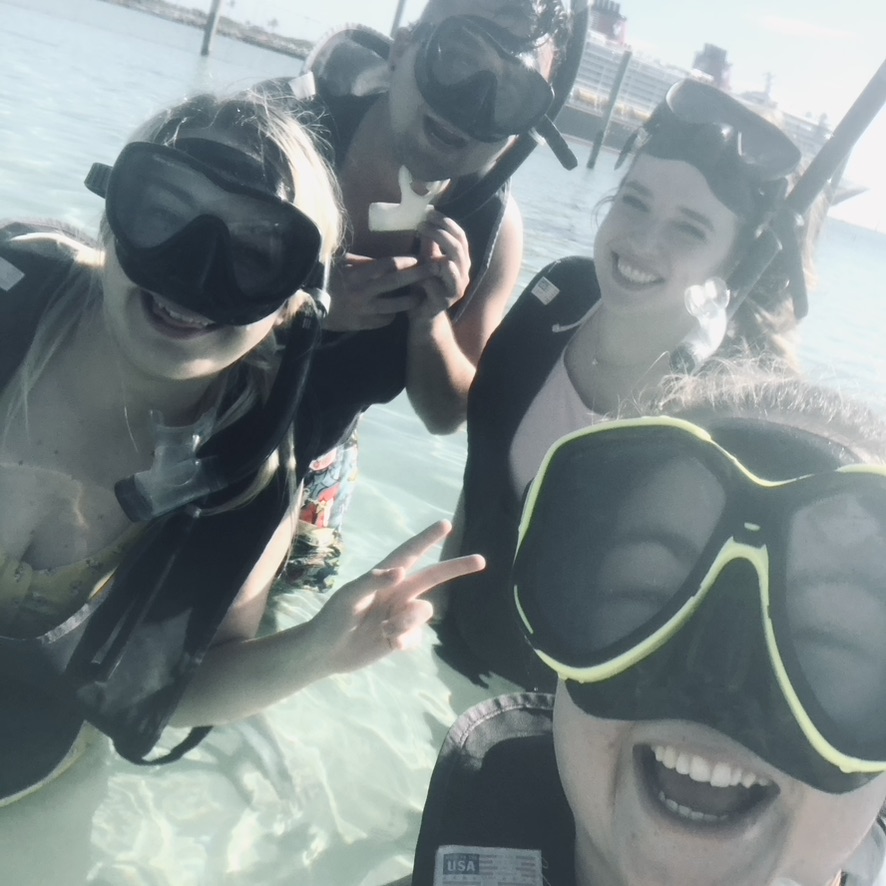 Selfie of a group of people wearing snorkels with disney cruise ship in the background at castaway cay.