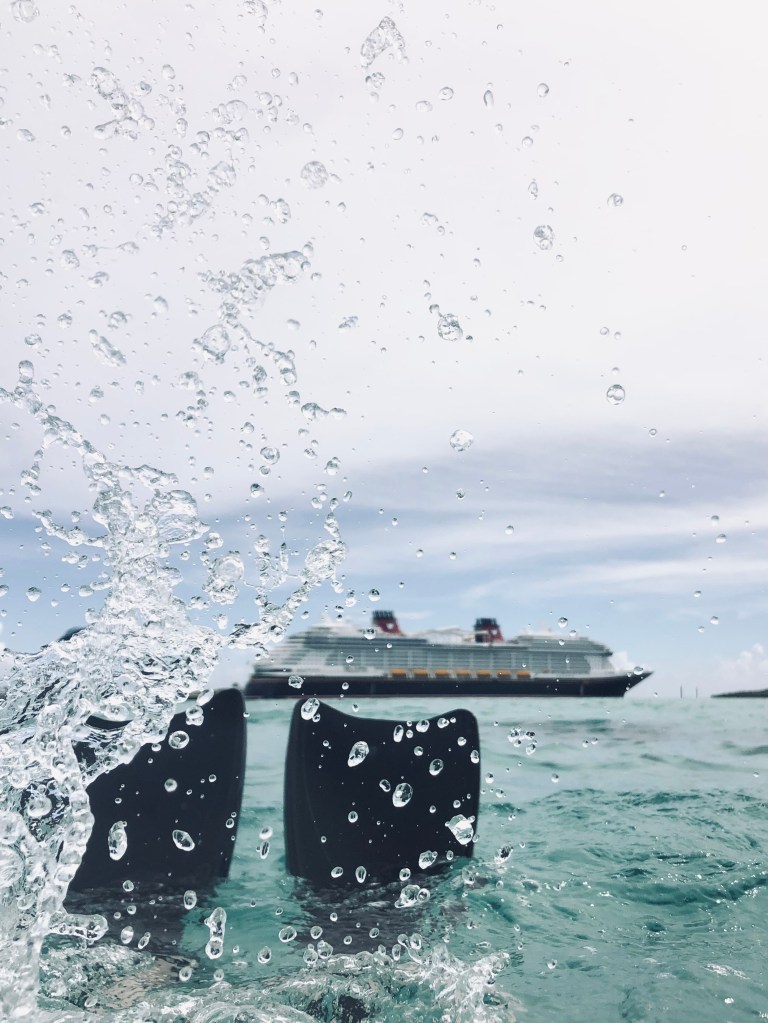 Flippers splashing water with disney cruise ship in background on Castaway Cay