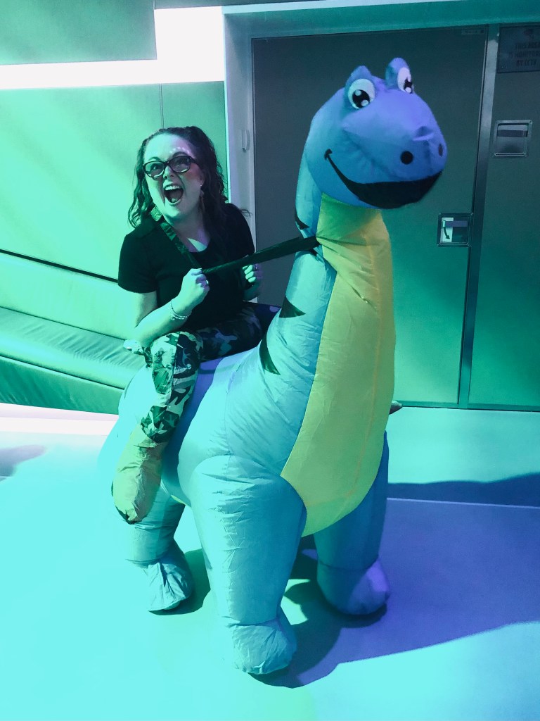 Girl dressed in an inflatable dinosaur costume at a crew party on a disney cruise ship