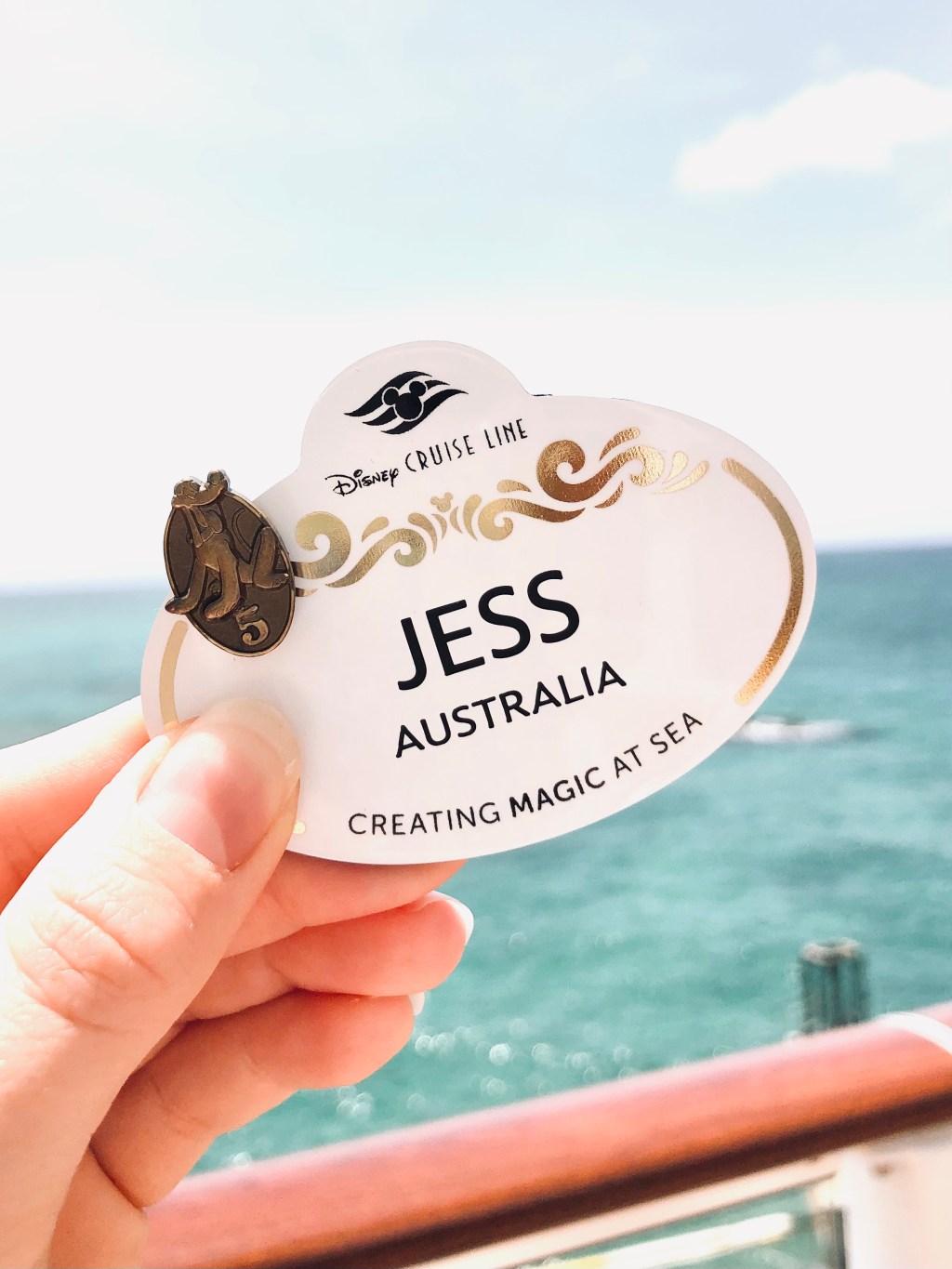 Disney Cruise Line Crew Member nametag with 5 year pin featuring Pluto character