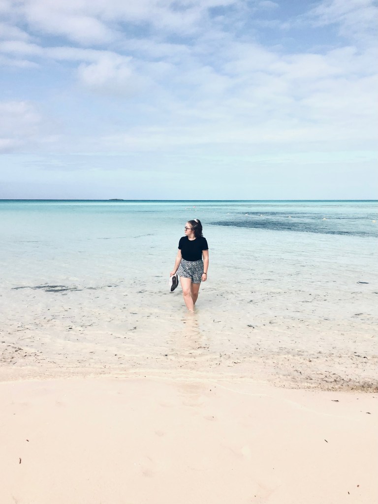 Girl wading in aqua colored ocean in Castaway Cay, Bahamas
