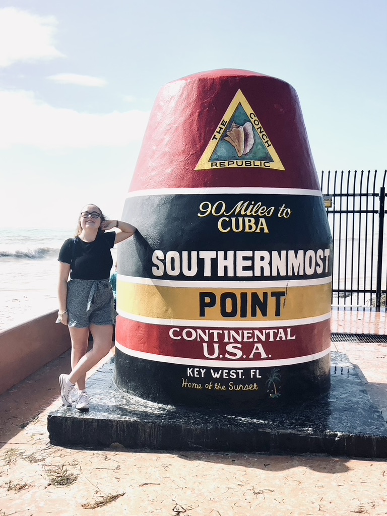 Girl posing next to Southernmost Point monument in Key West, Florida