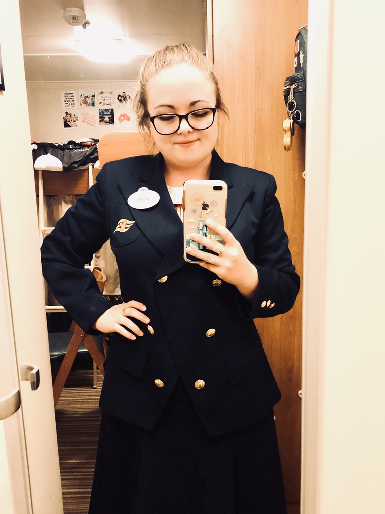 Disney Cruise Line Cast Member taking selfie in cabin in navy merchandise costume.