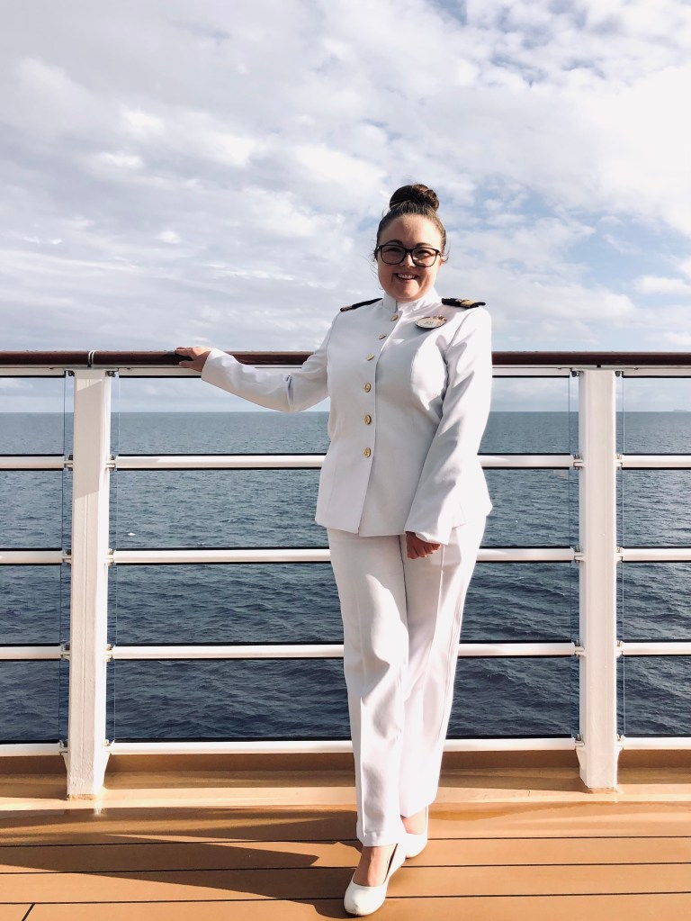 Disney Cruise Line officer smiling in officer whites on cruise ship deck