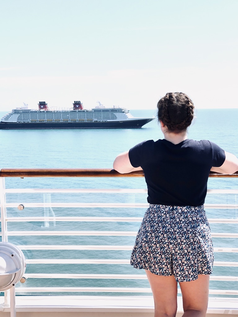 Girl looking out at Disney Cruise Ship from deck