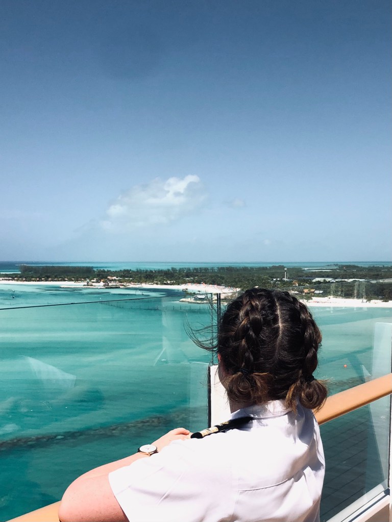 Disney cruise ship officer looking out from deck at Castaway Cay island