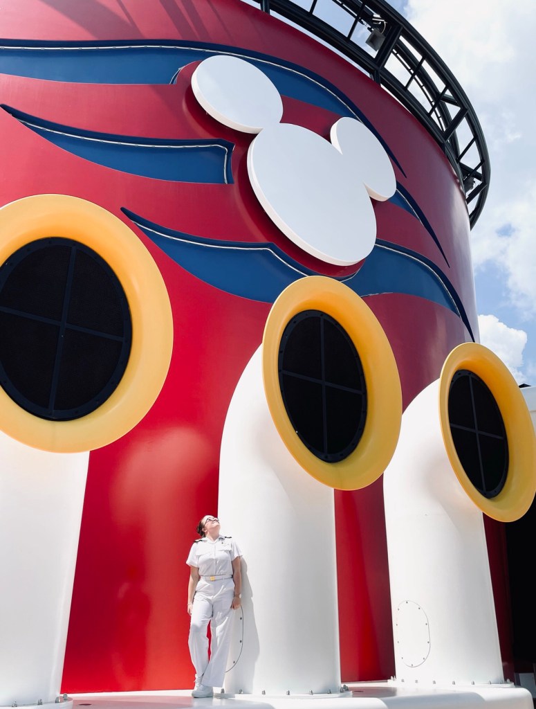 Disney cruise ship officer looking up at mickey mouse funnel.