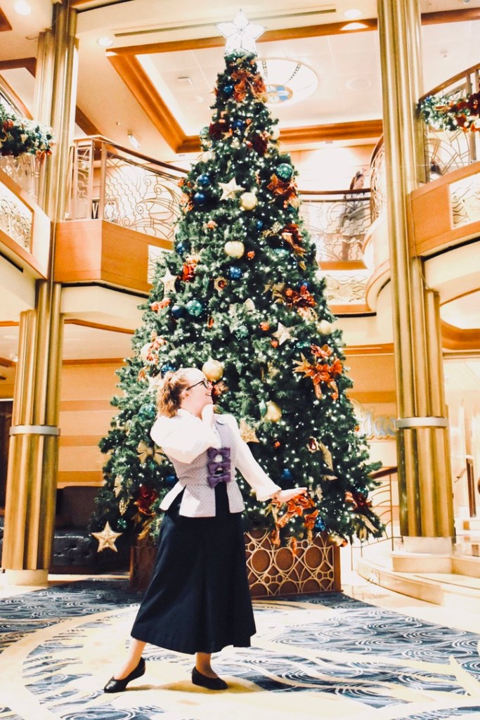 Bibbidi Bobbidi Boutique fairy godmother posing in front of Christmas tree on Disney Dream cruise ship