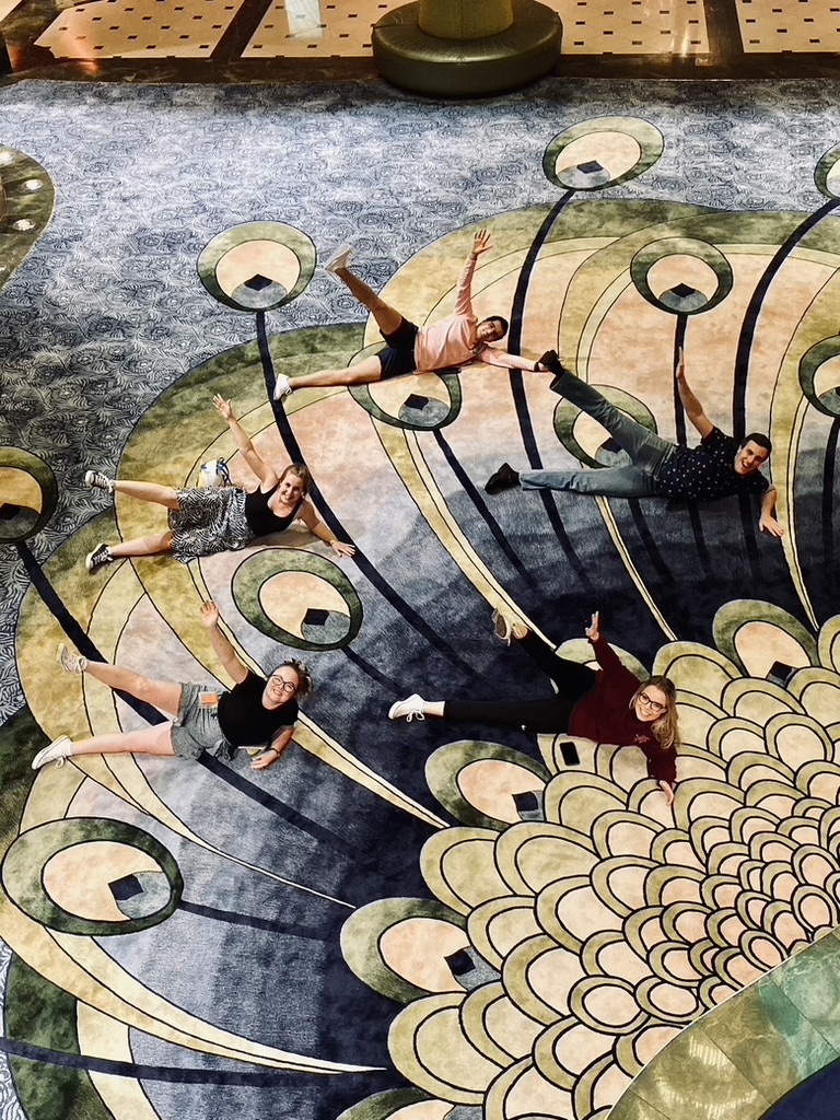 Group of friends lying on the carpet of the Disney Fantasy atrium