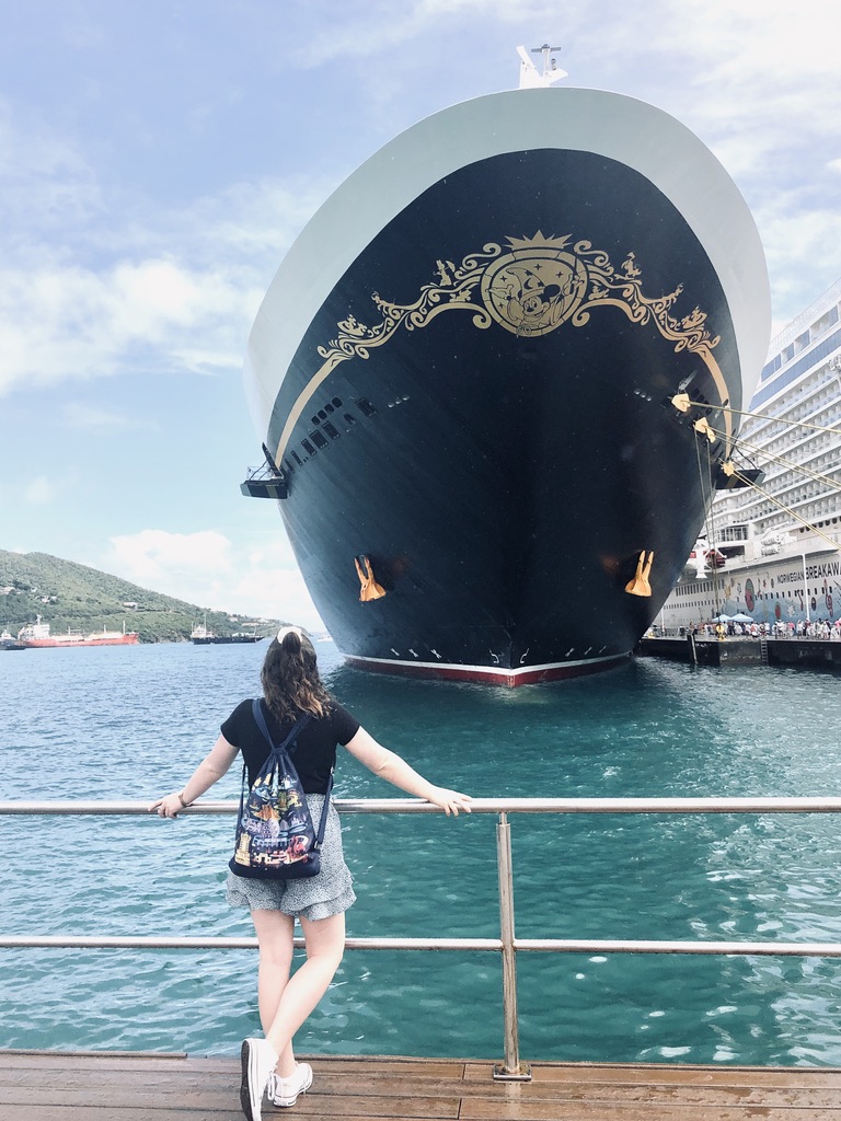 Girl looking back at Disney Fantasy cruise ship docked in Tortola, Virgin Islands