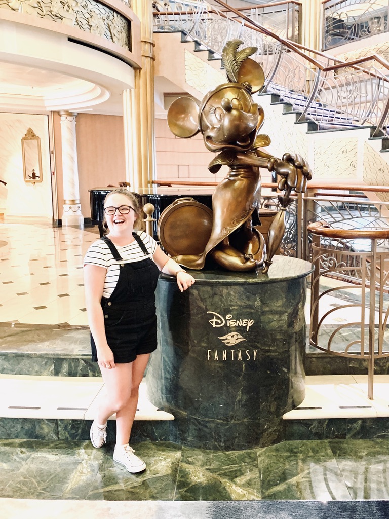 Girl smiling with Disney Fantasy statue