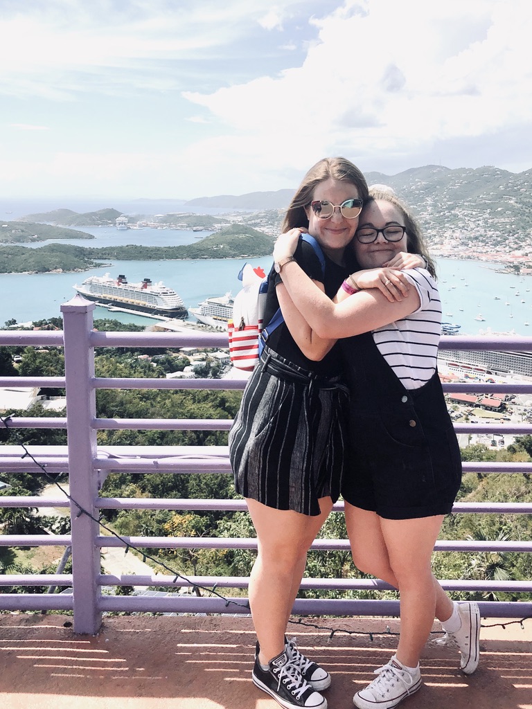 Two friends hugging at the top of Paradise point at St Thomas, Virgin Islands with cruise ships in the background