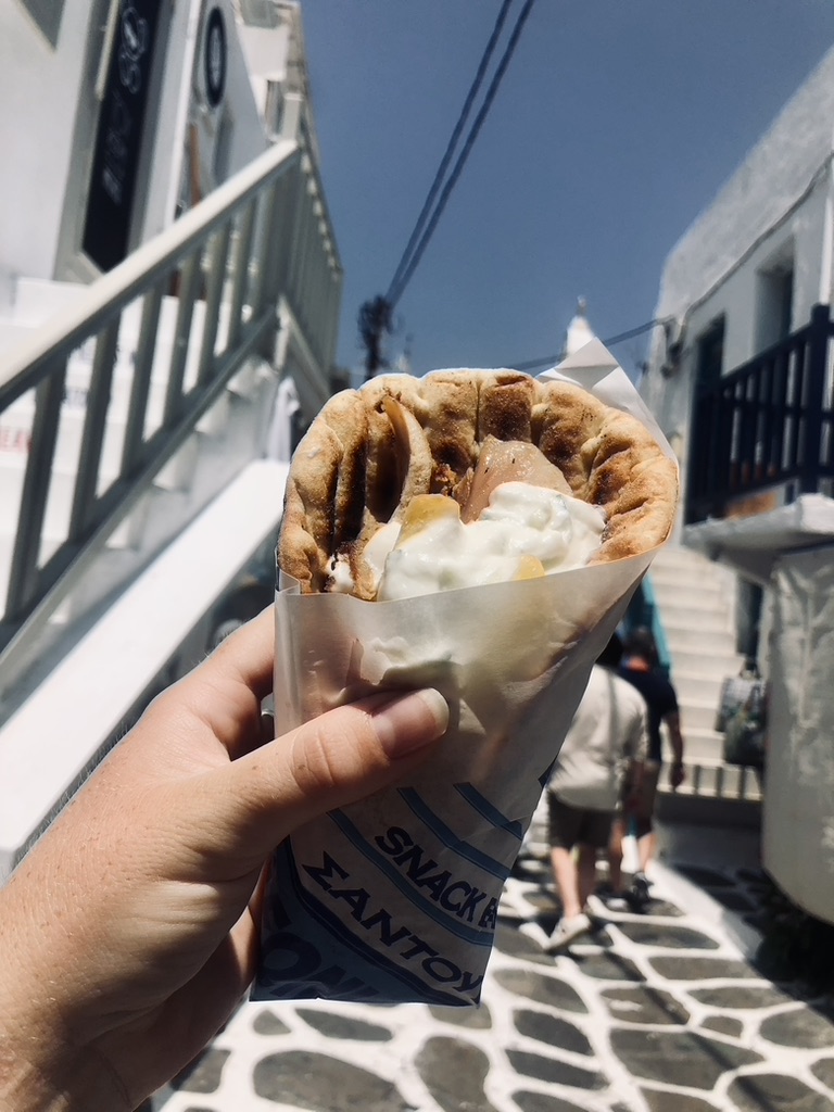 Hand holding gyro on a street in Mykonos, Greece