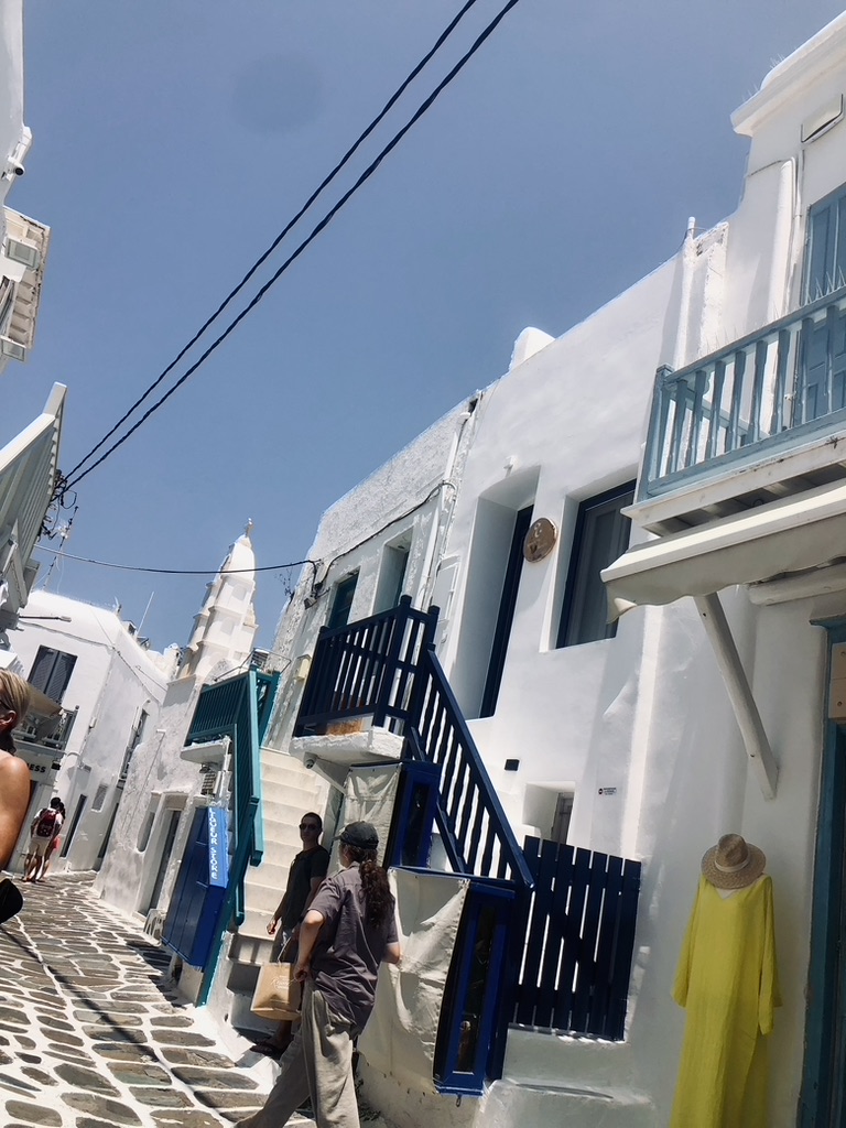 Street with cobble stone footpath and colorful stairs to houses in Mykonos, Greece