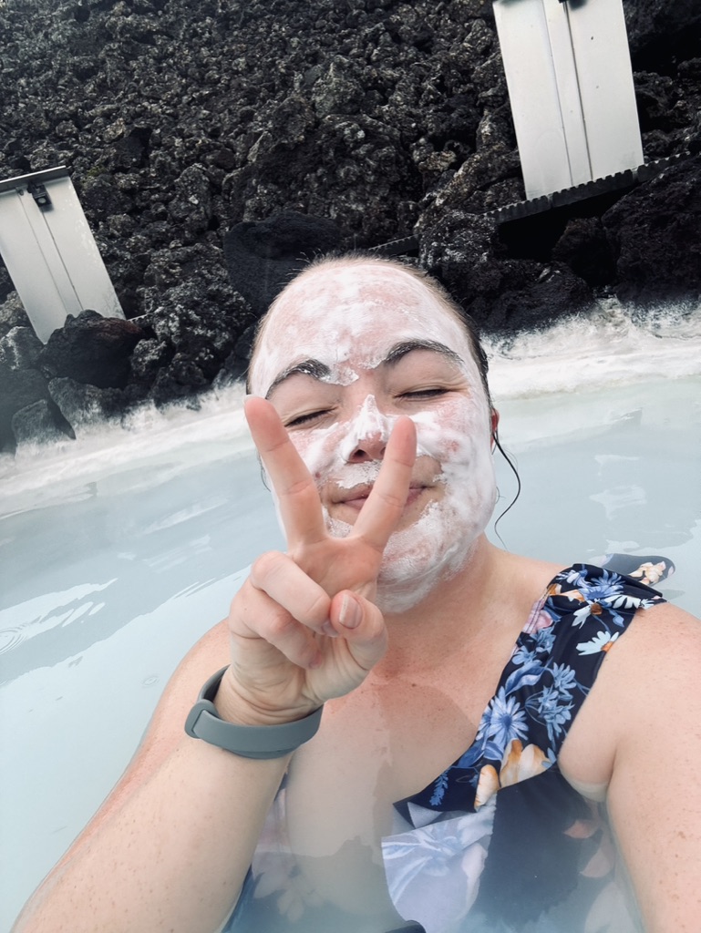 Girl taking selfie with mud mask in blue water at Blue Lagoon, Iceland