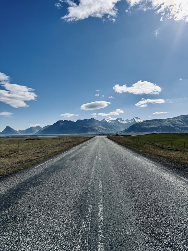 Long straight empty road with mountains in distance in Iceland