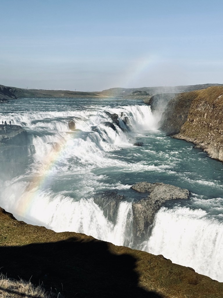 Gullfoss waterfall with cascading waterfalls in canyon with rainbow from mist in Iceland