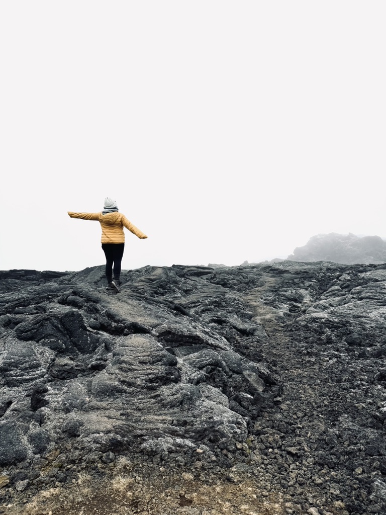 Girl in yellow posing on lava field around Mytavn, Iceland