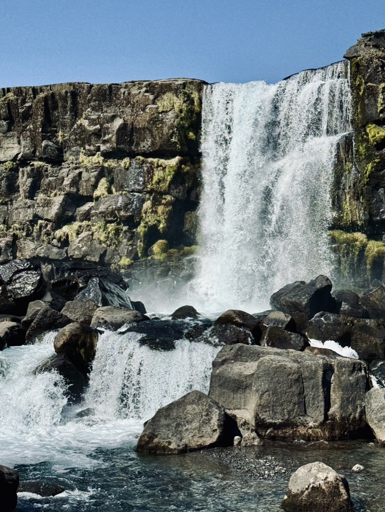 Waterfall flowing over mossy rocks. Oxararfoss at Thingvellir National Park, Iceland.