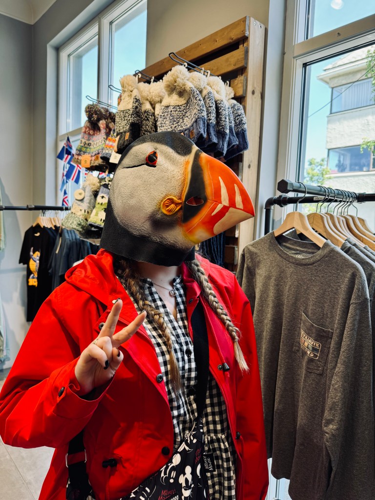 Girl posing wearing a Puffin mask in a tourist shop in Reykjavik, Iceland
