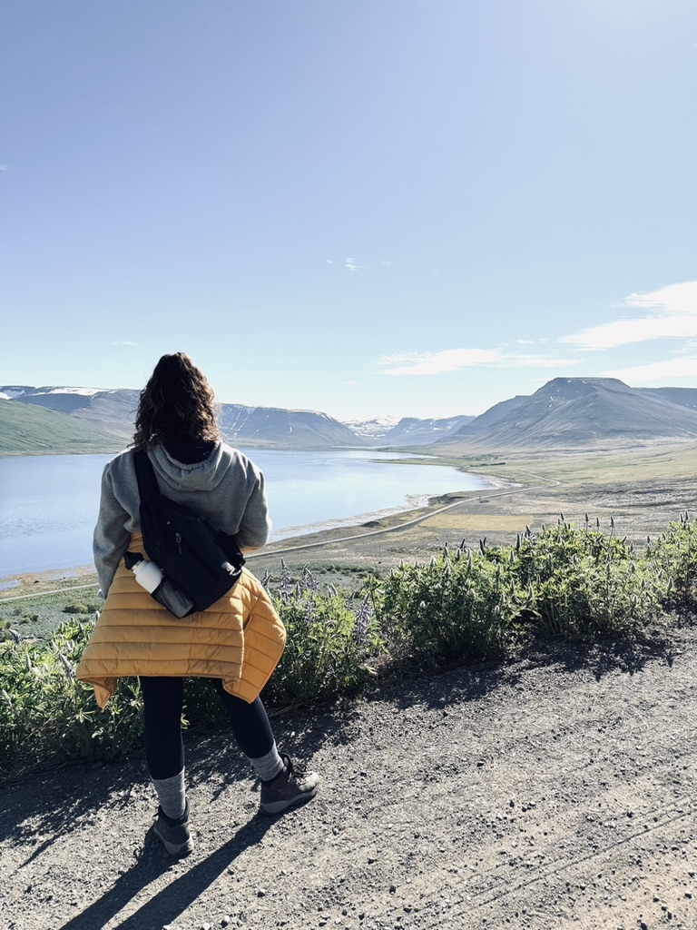 Girl looking at view from the top of Sandafell Mountain in Westfjords of Iceland.