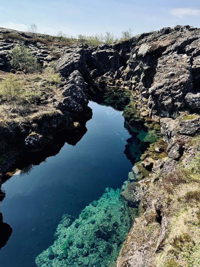 Clear blue water in a canyon between two tectonic plates at Thingvellir National Park, Iceland