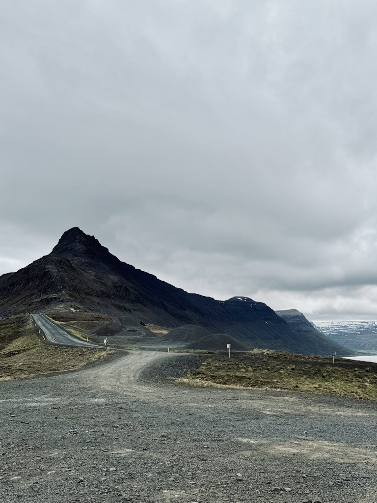 Empty road leading to a pointy mountain in the Westfjords of Iceland