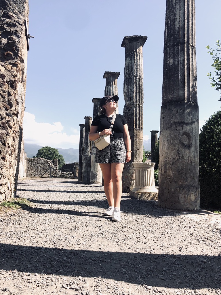 Girl walking through column ruins in Pompeii, Italy