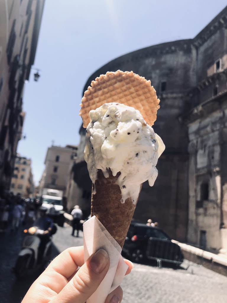 Hand holding melting vanilla gelato in Rome, Italy