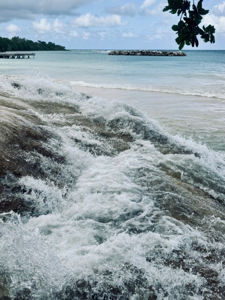 Waterfall flowing into ocean at Dunns River Falls in Jamaica