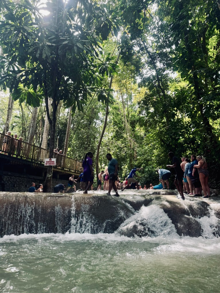 People swimming in waterfall pools at Dunns River Falls in Jamaica
