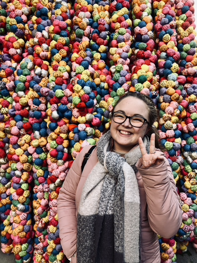 Girl smiling at Yasaka Koshin Temple in Kyoto, Japan with colorful craft balls