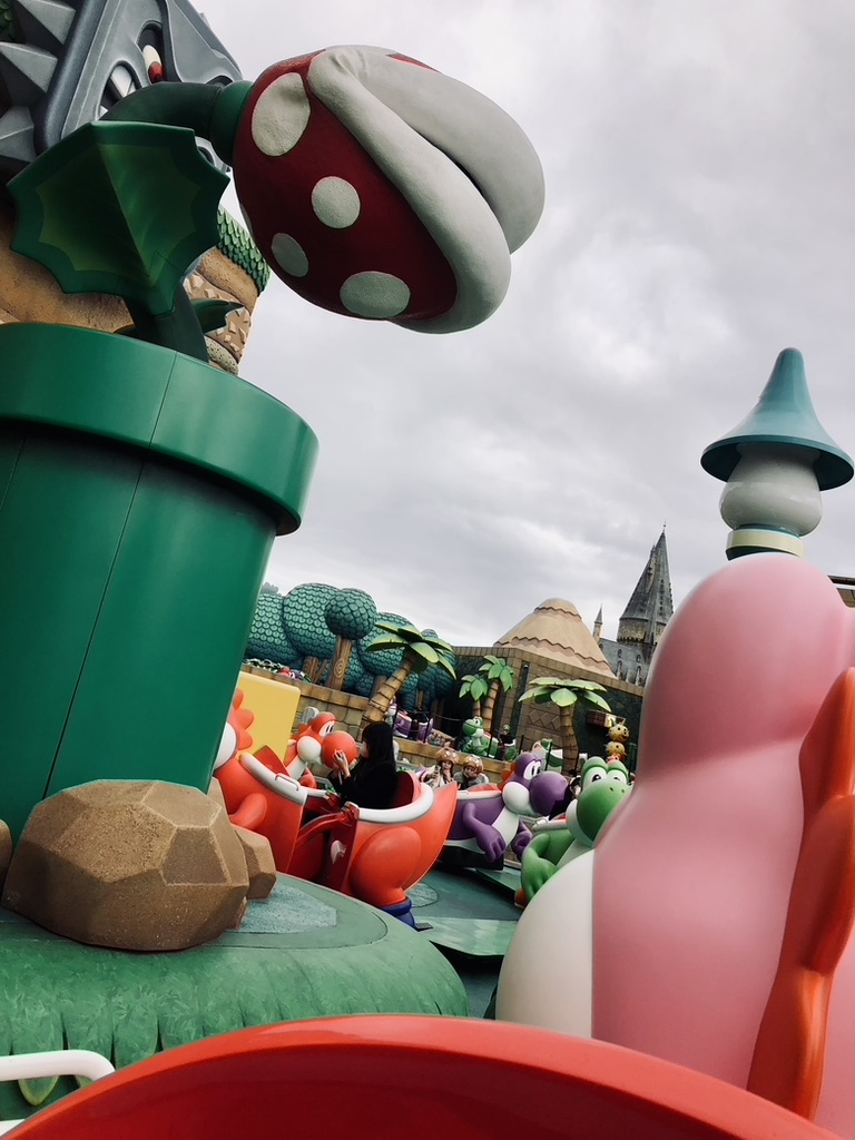 View from Yoshi ride at Super Nintendo World Japan. Giant mario characters surround the yoshi ride cart.