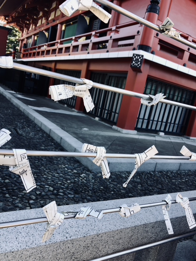 Bad luck fortunes tied to string at senso-ji temple in Asakusa, Tokyo, Japan.