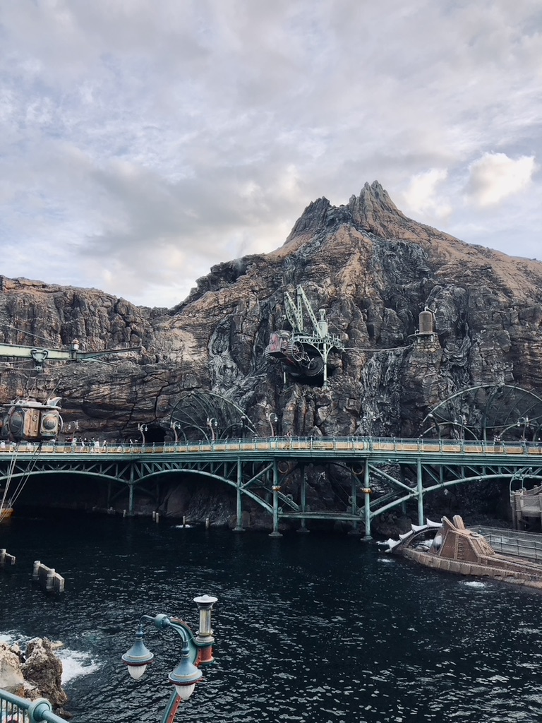 Inside of volcano area at Tokyo DisneySea in Japan. Submarine ride and water surrounded by volcano.