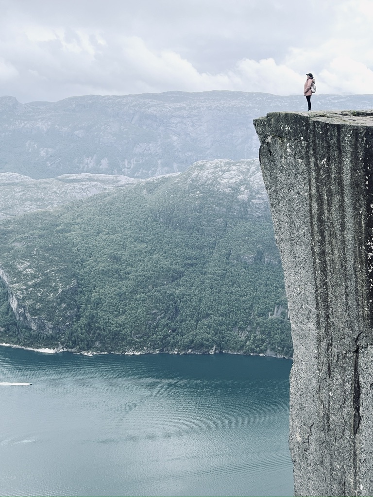 Girl standing at the top of the iconic spot at Pulpit Rock, Norway