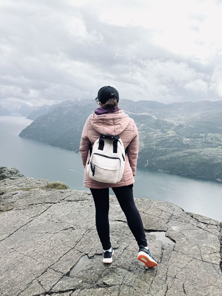 Girl looking out over the incredible view of fjords from the top of Pulpit Rock, Norway