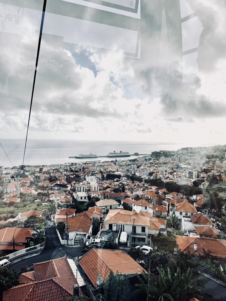 View of buildings and ships in distance from cable car in Funchal, Portugal