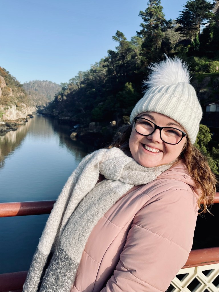 Girl in pink coat smiling at Cateract Gorge in Launceston, Tasmania