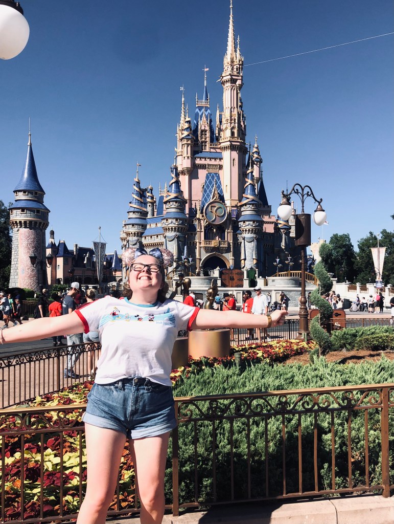 Girl smiling in front of Cinderellas castle at Magic Kingdom for the 50th anniversary