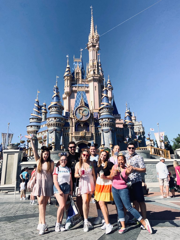 Group of crew members on a day off to Magic Kingdom, standing in front of Cinderellas castle for the 50th anniversary