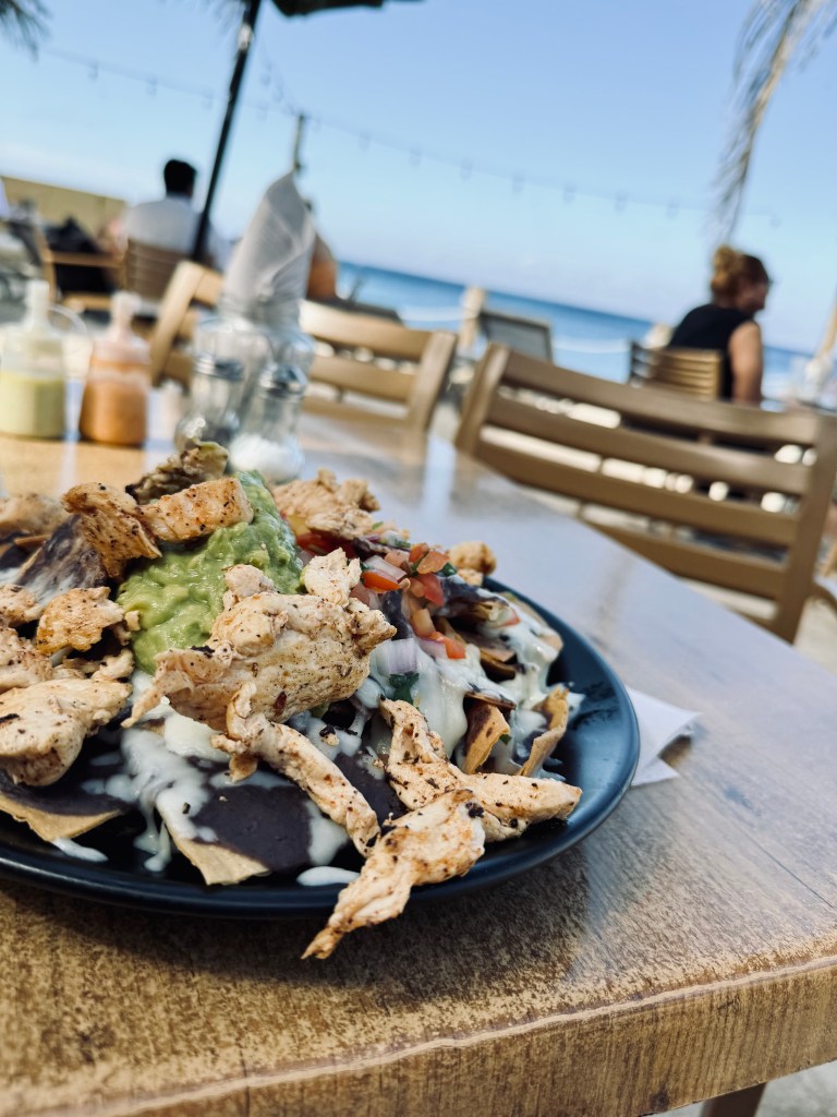 Chicken nachos on a table with view of ocean in background at Jeanie's restaurant in Cozumel, Mexico