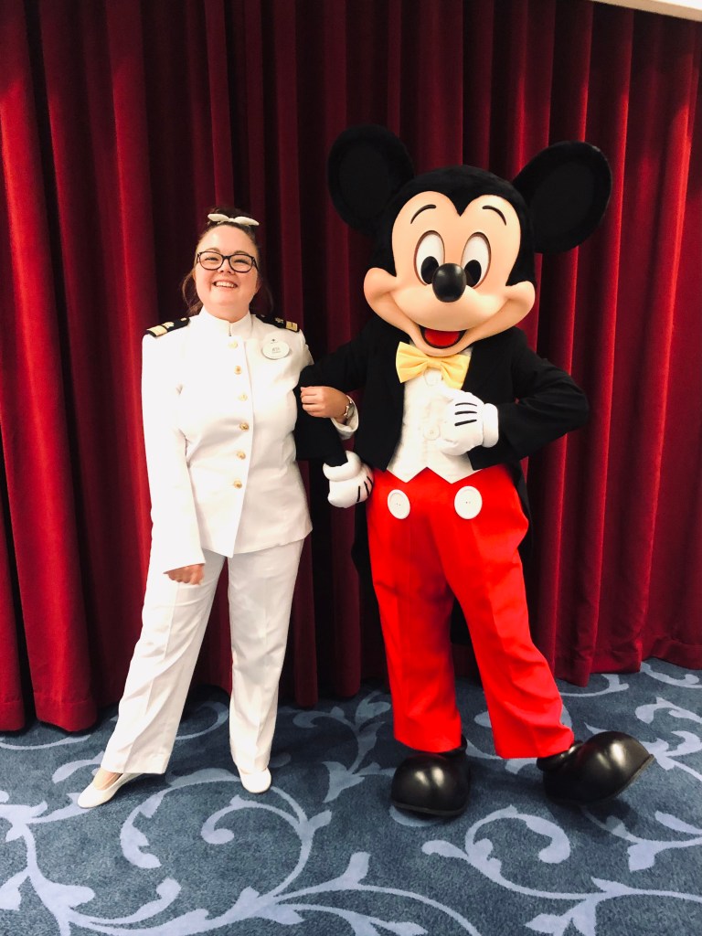 Disney Cruise Line officer with Mickey Mouse onboard a disney cruise ship