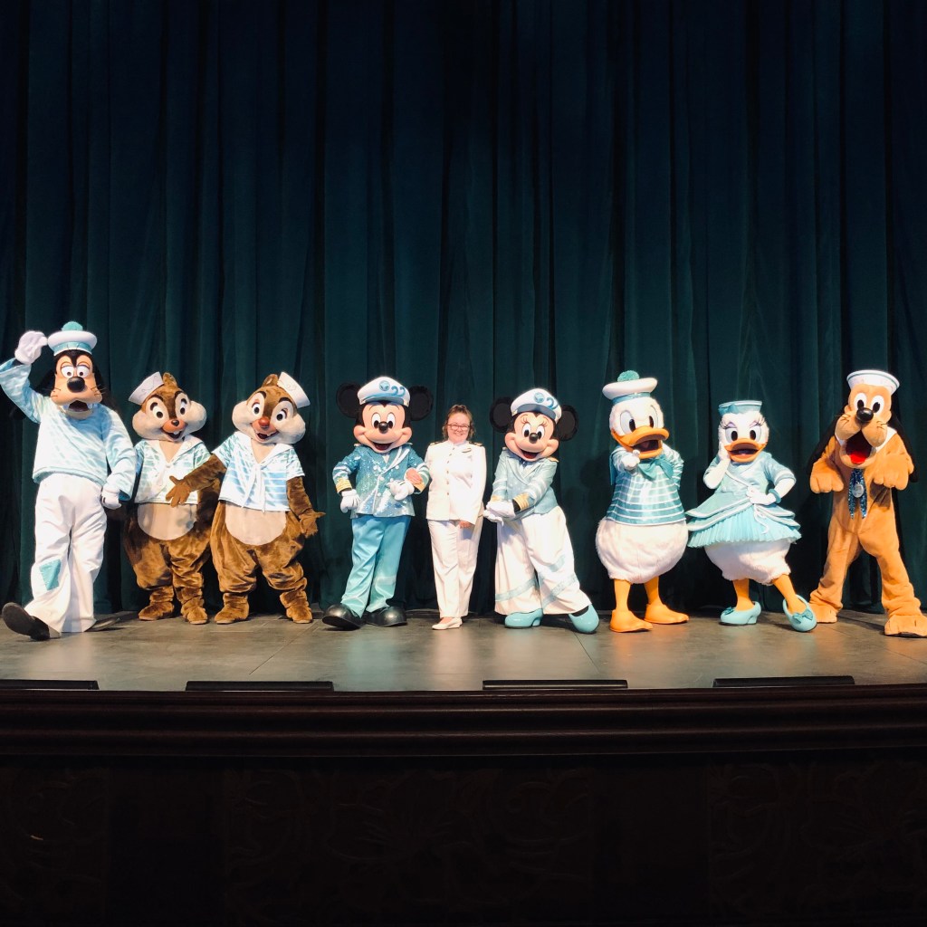 Disney Cruise Line 25th Anniversary Mickey and friends with disney officer on stage