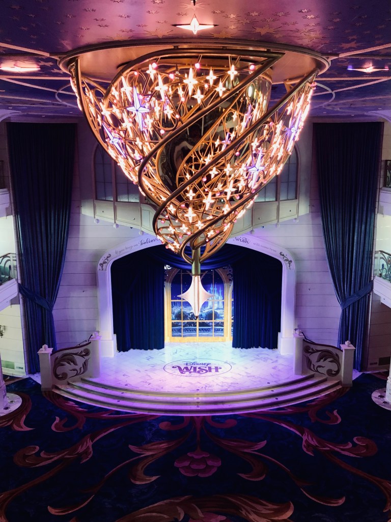 Beautiful chandelier lit up in the Grand Hall onboard the Disney Wish