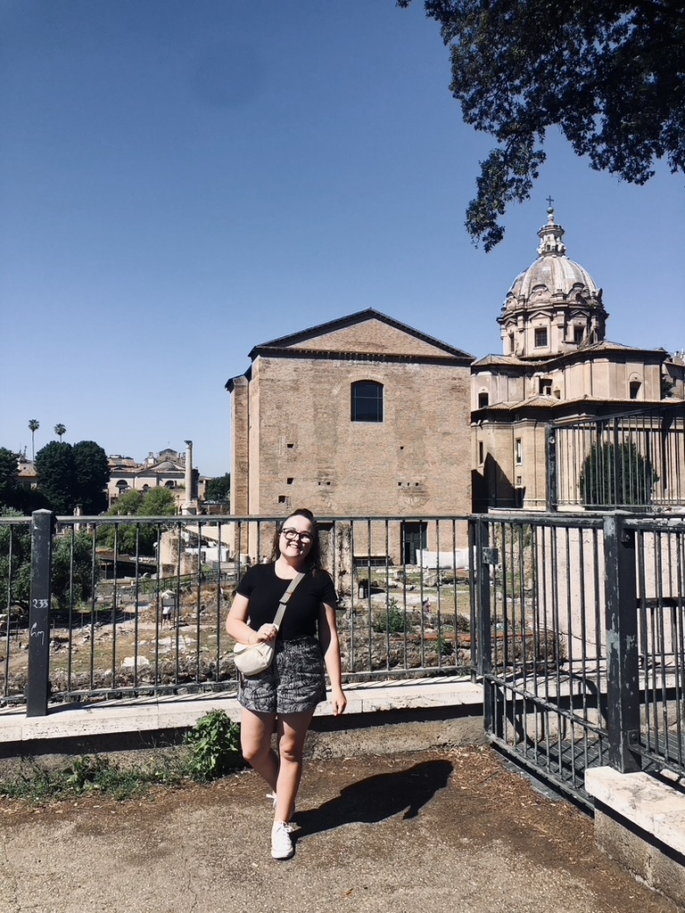 Girl standing in front of ancient ruins at Roman Forum, Rome Italy