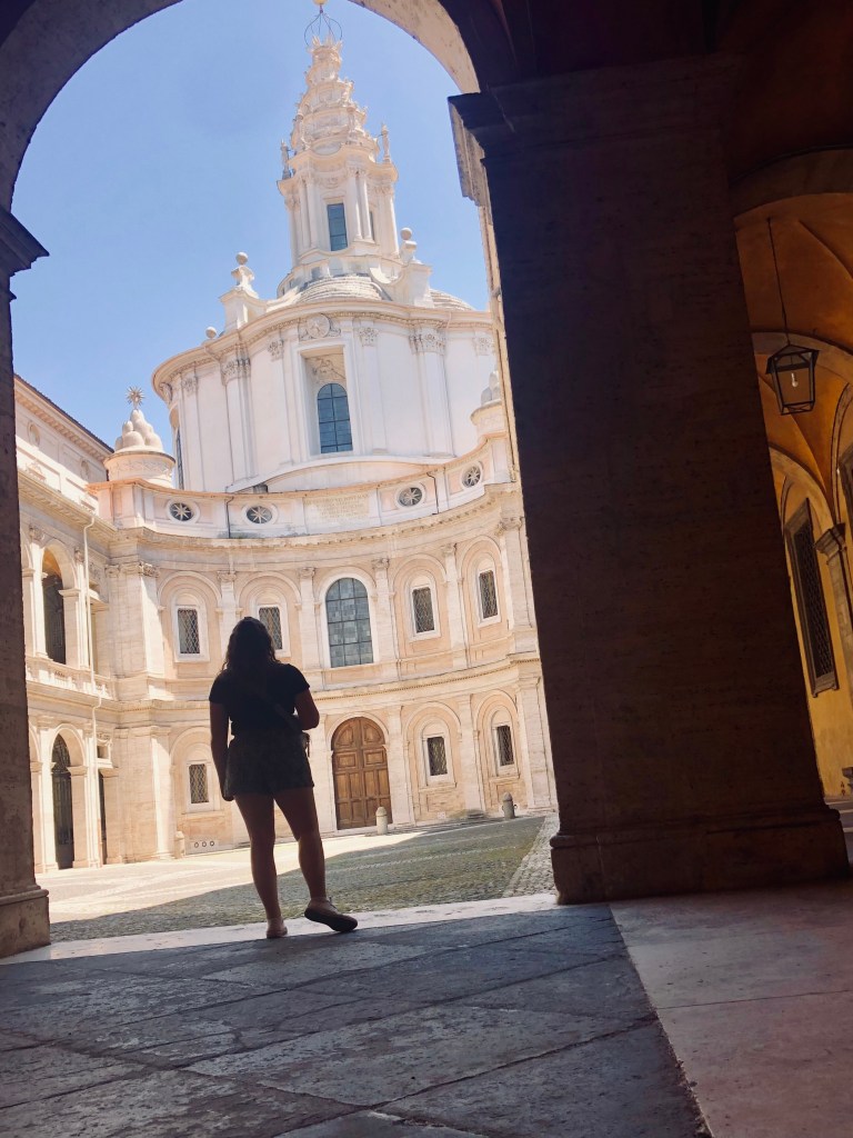 Girl shadow in arch way looking up at old architecture in Rome, Italy