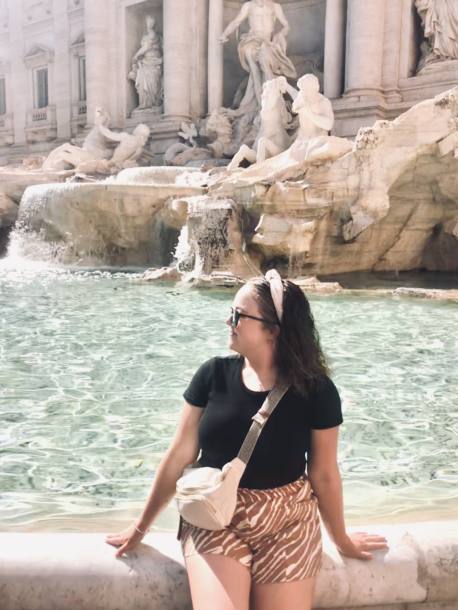 Girl looking back at Trevi Fountain in Rome, Italy